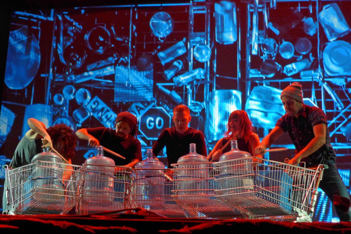 Akteure von Stomp machen Musik mit leeren Wasserflaschen