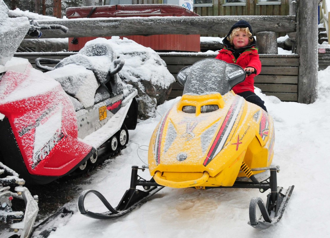Kind auf einem Kinderschneemobil