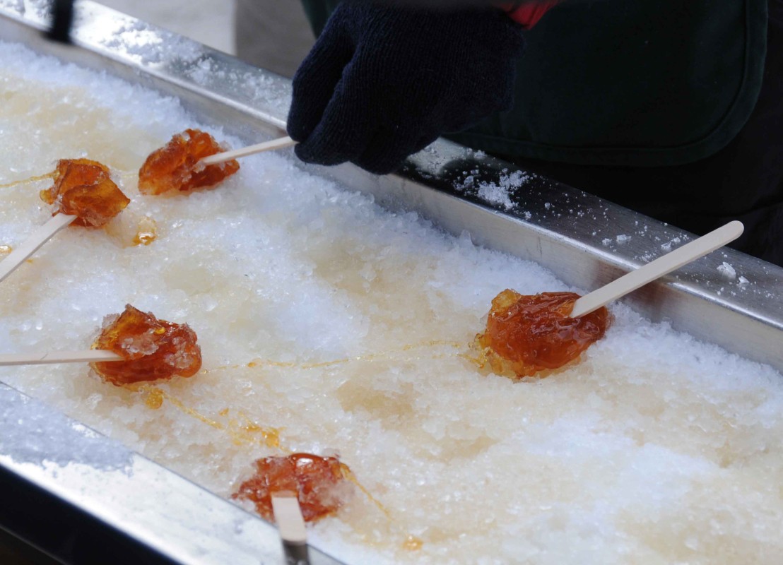 Ahornsirup-Lollies. Einfach heißen Ahornsirup in den Schnee gießen und die erkaltende Masse aufrollen. Fehlt hier nur der Schnee